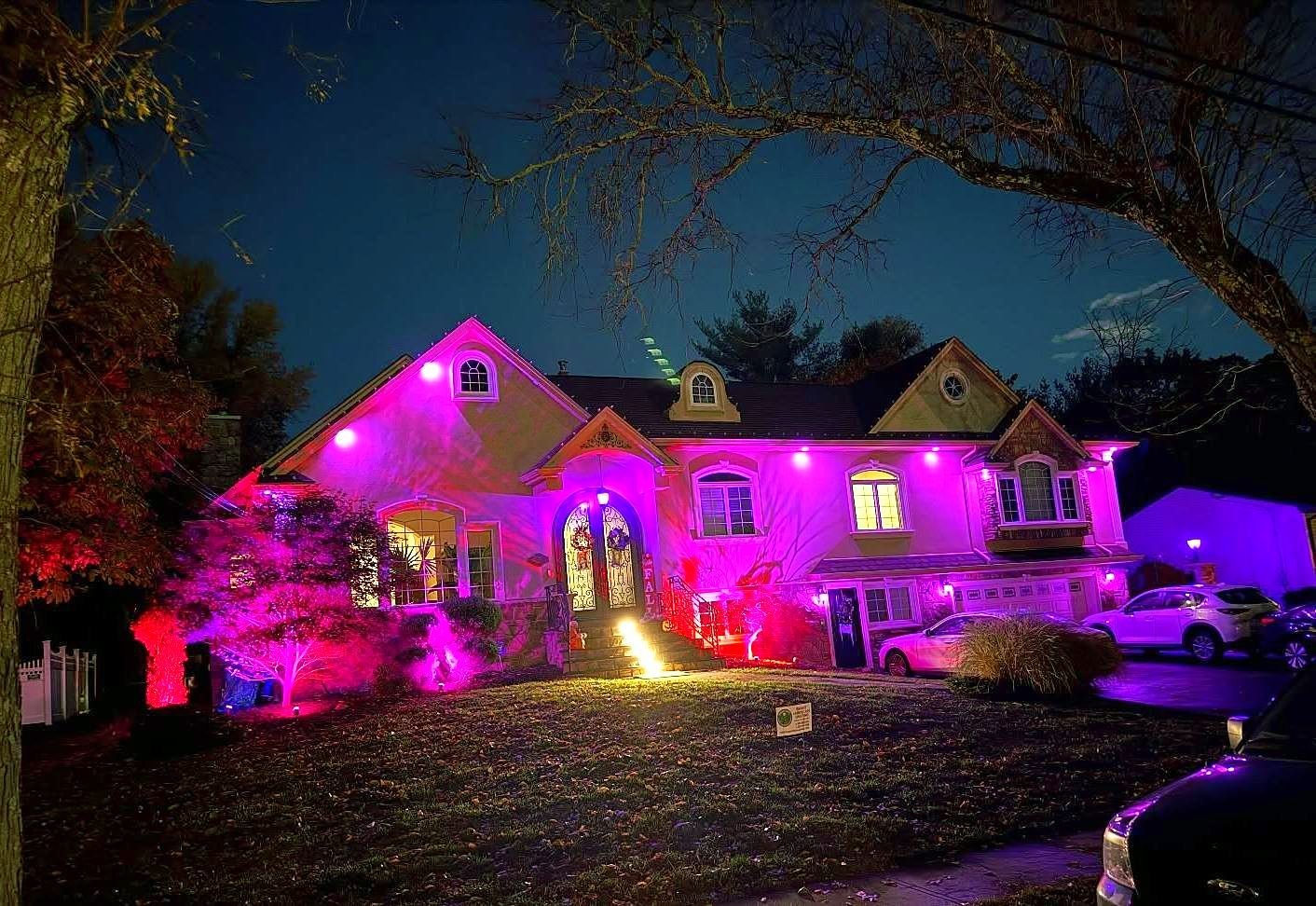 Stucco colonial washed in purple light from color changing uplights